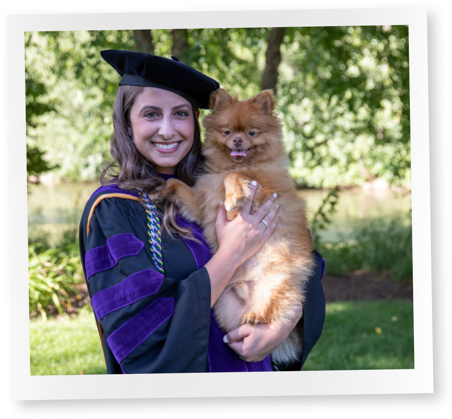 polaroid of female student smiling in cap and gown holding her dog