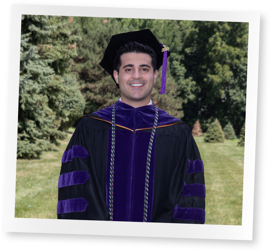polaroid of male student in grass area smiling with cap and gown on