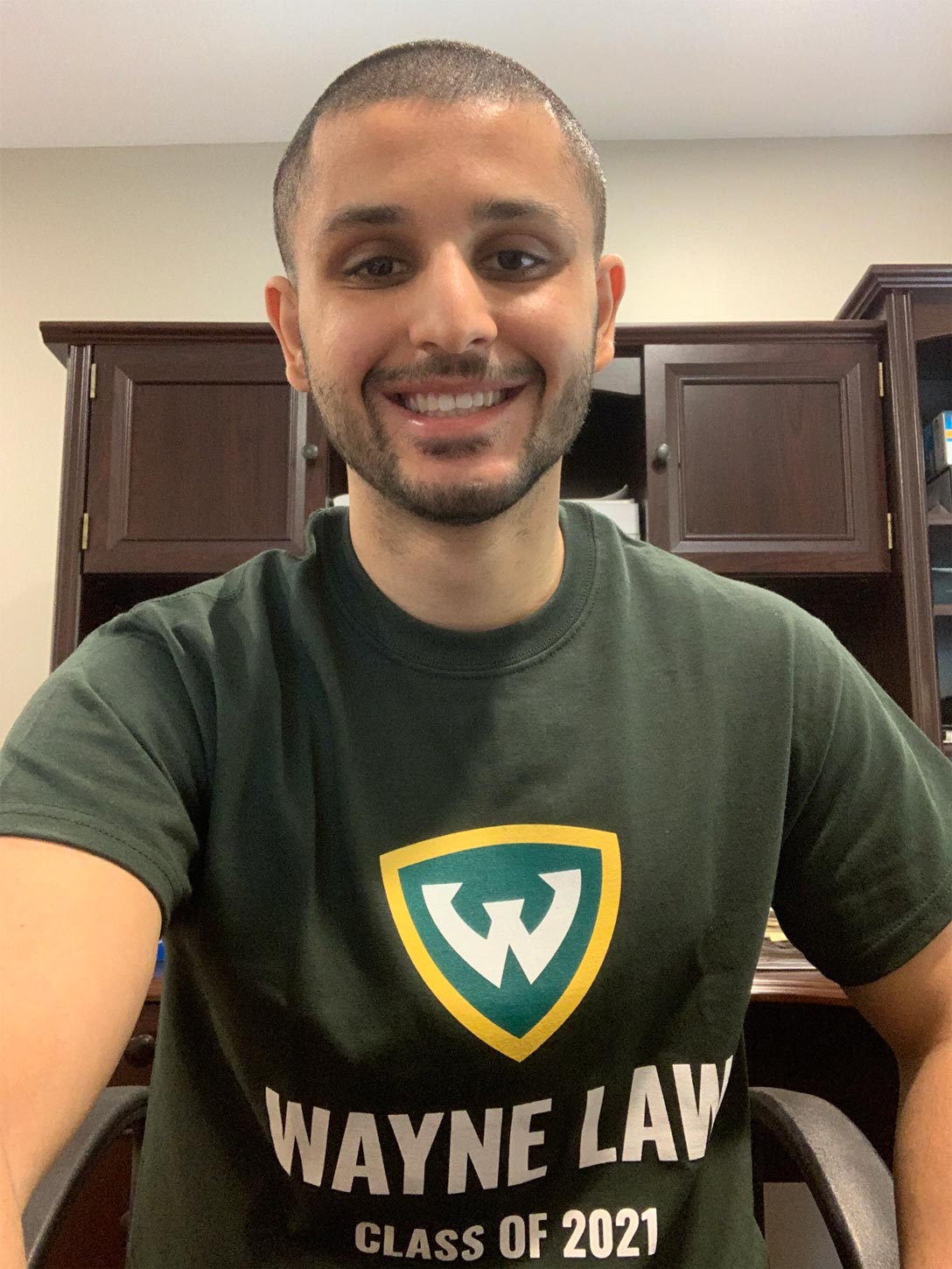 Boulos Saba smiles while taking a selfie, wearing  a Wayne Law class of 2021 shirt