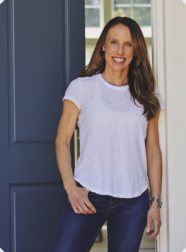 Carrie Dorr in white t-shirt and blue jeans smiling