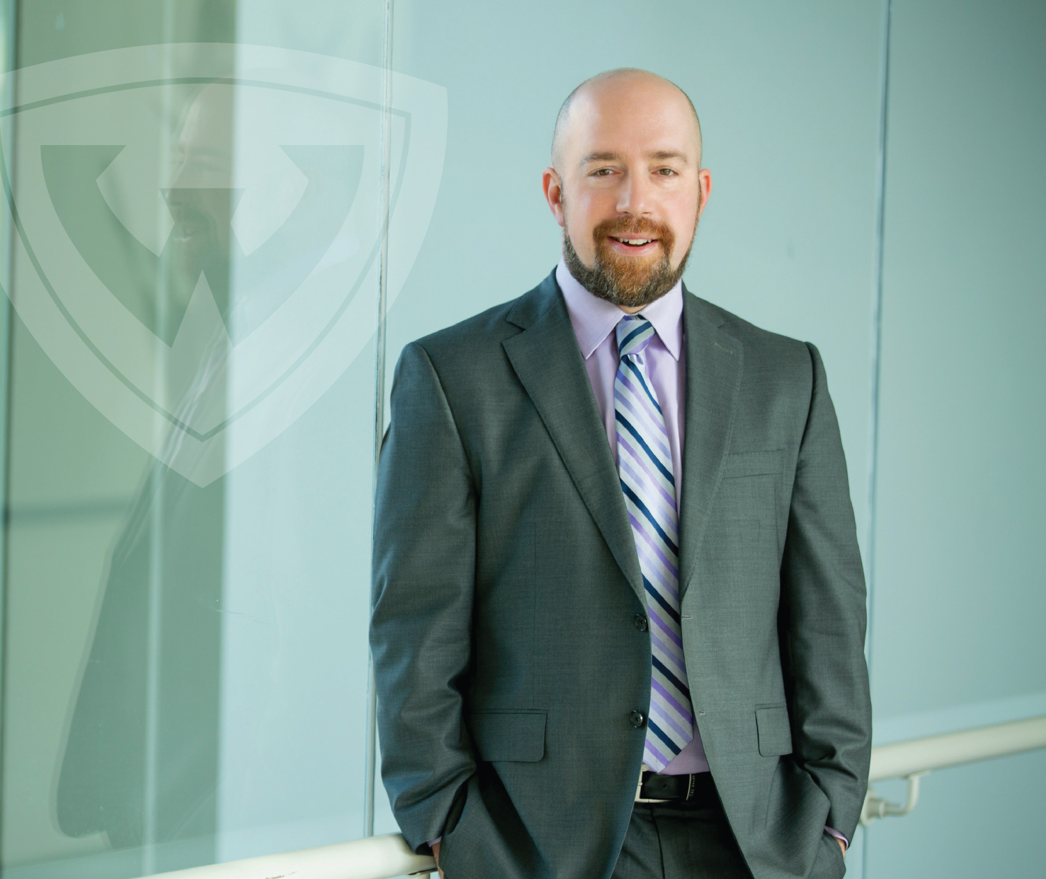 Lance Gable smiling wearing suit with hands in pocket