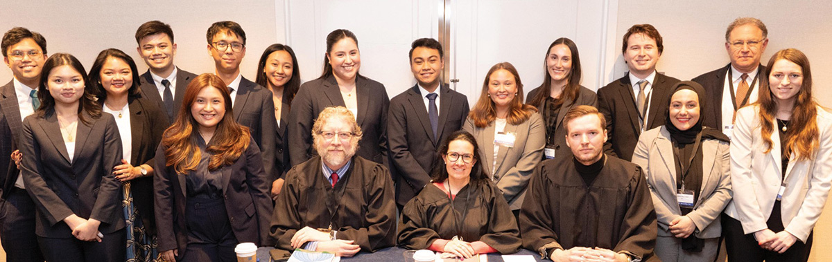 Wayne State University Law School team consisted of eighteen diverse individuals smiling in a professional moot court or legal seminar